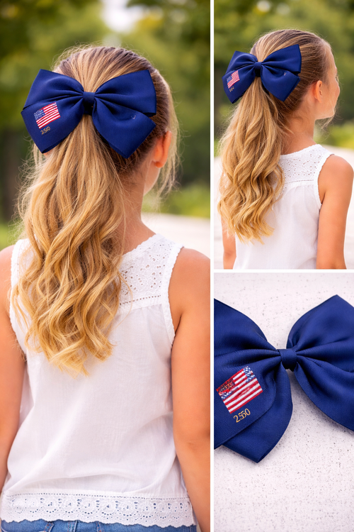 Blue hair bow with American flag design worn by a person with long blonde hair.