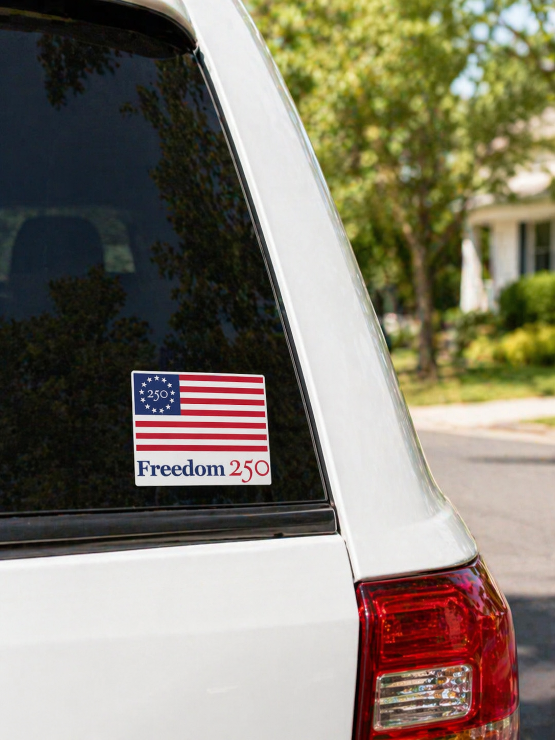 American flag sticker with 'Freedom 250' text on a car window