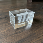 Clear glass block with 'Freedom 250' engraving on a wooden surface