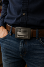 Person wearing a navy shirt and jeans with a belt featuring a 'Freedom 250' buckle.