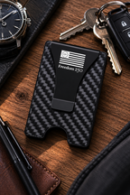 Carbon fiber patterned cardholder with American flag design on a wooden surface with keys and a watch.