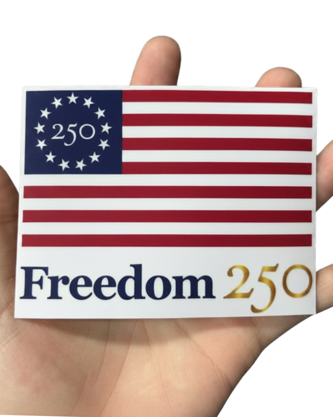 Sticker with American flag design and 'Freedom 250' text held between fingers