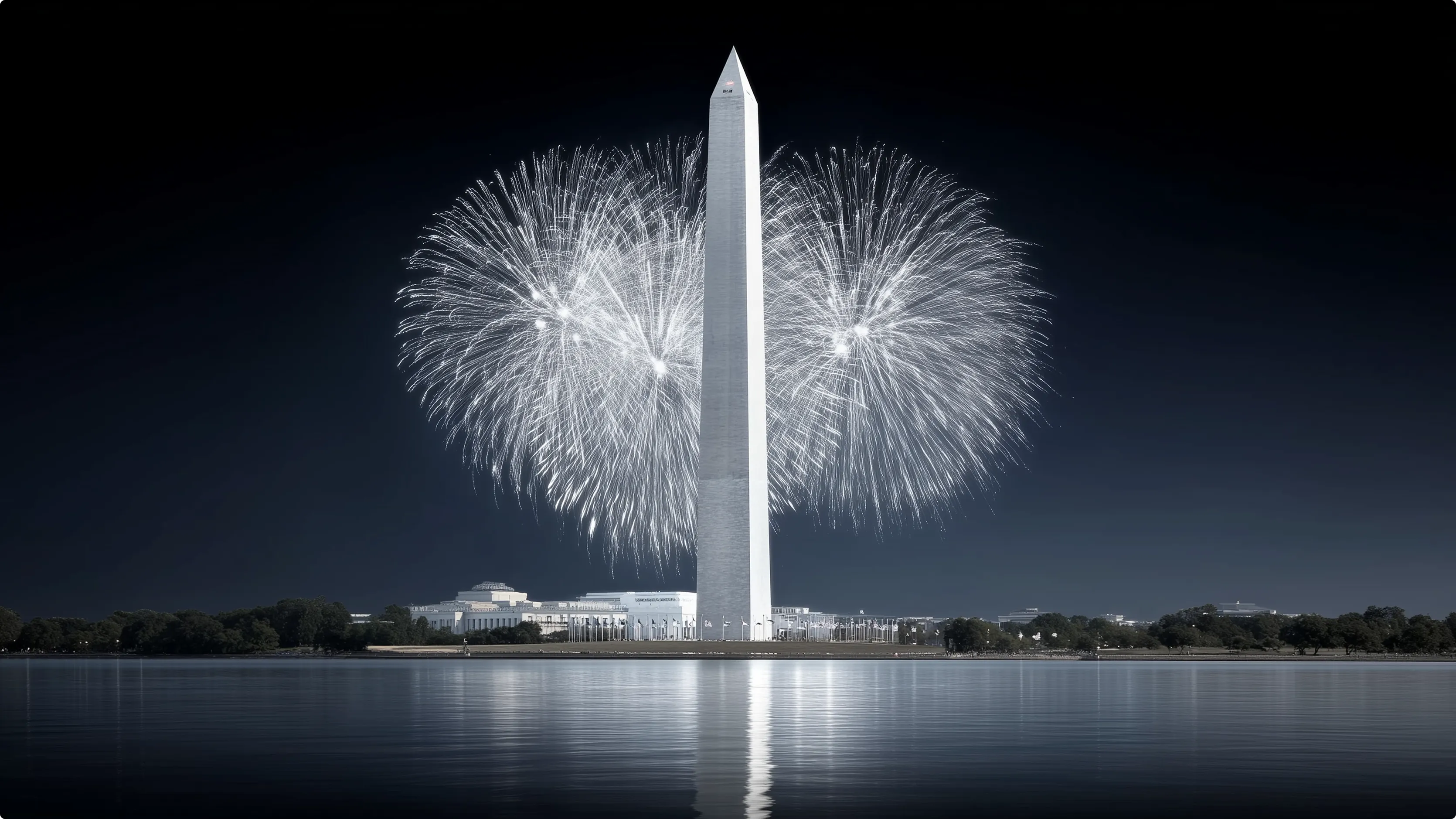 Fireworks exploding behind the Washington Monument with a reflection on the water.